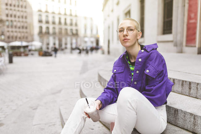 Молода жінка в місті користується парфумами. — стокове фото