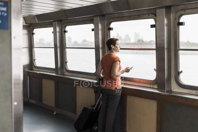Woman on a ferry looking out of window — Stock Photo