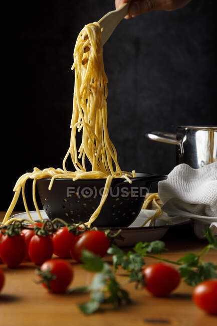 Pasta with tomatoes and basil on a dark background — Stock Photo