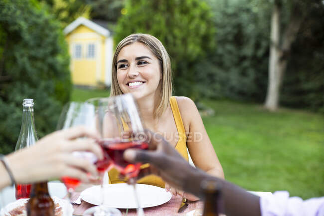 Amici brindisi con vino ata cena estiva in giardino — Foto stock