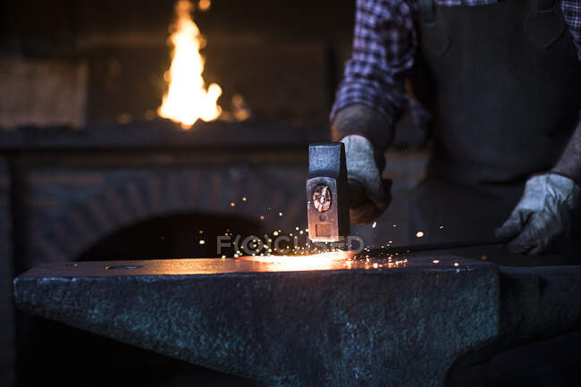 Close-up of blacksmith working with hammer at anvil in his workshop — Stock Photo