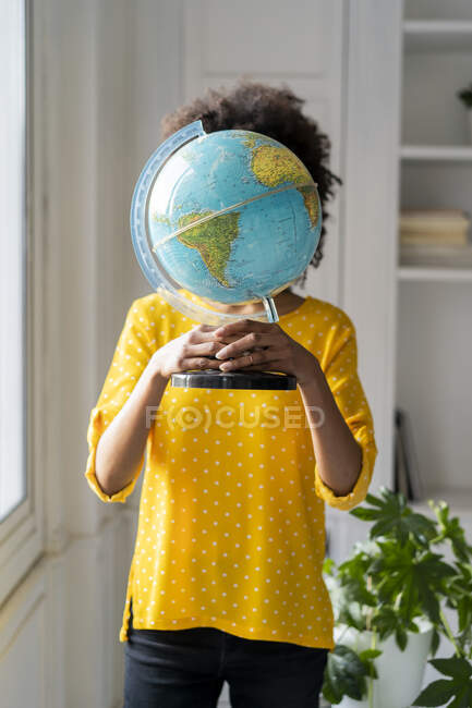 Mujer sosteniendo globo ocultando cara - foto de stock