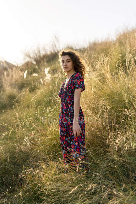 Портрет серьезной молодой женщины, стоящей на лугу — стоковое фото