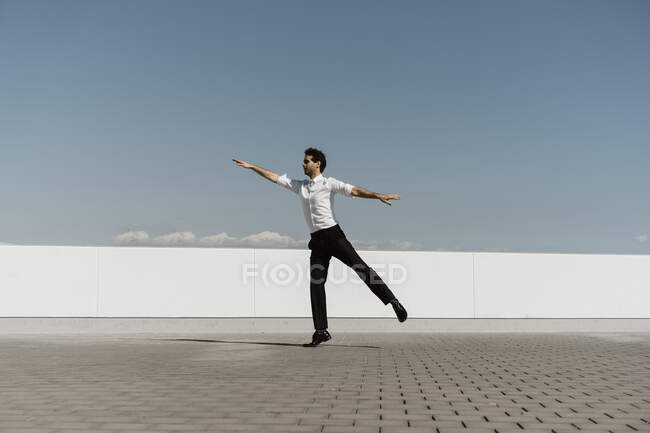 Ballet dancer with headphones practising on roof terrace — Stock Photo