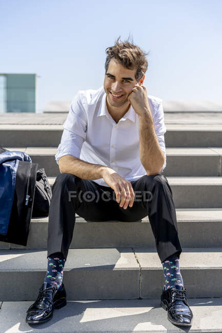 Ritratto di uomo d'affari felice seduto sulle scale che si prende una pausa — Foto stock