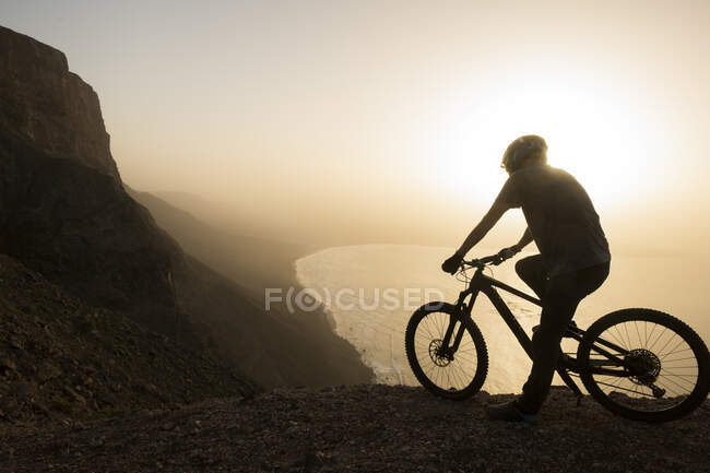 Espagne, Lanzarote, VTT en excursion sur la côte au coucher du soleil profitant de la vue — Photo de stock