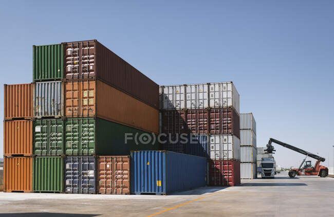 Grue levage conteneur de fret sur camion sur le site industriel — Photo de stock