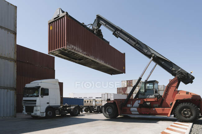 Contenitore di carico di sollevamento gru su camion sul sito industriale — Foto stock