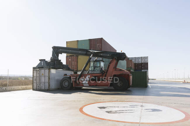 Кран и стопка контейнеров на промышленной площадке — стоковое фото