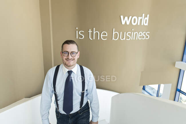 Портрет довірливого бізнесмена, який піднімається сходами в сучасному офісі. — стокове фото