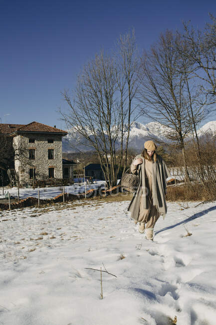 Італія, Лімана, жінка з кошиком пробирається крізь вкритий снігом краєвид. — Stock Photo