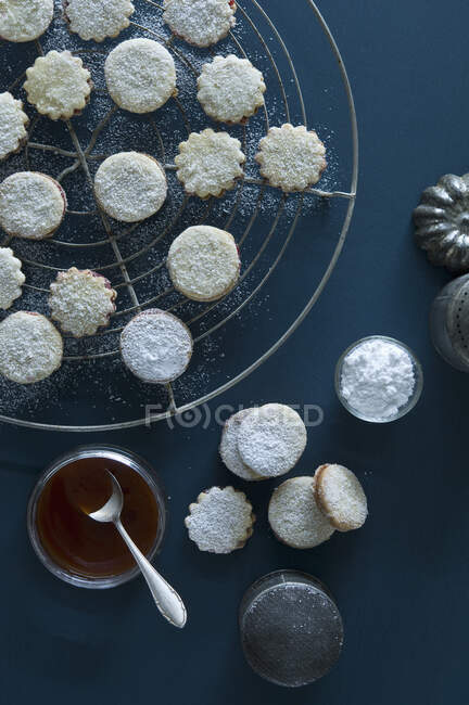Рождественские печенья Spitzbuben на выпечке сетке, варенье в банке, шиповник варенье, глазурь сахар — стоковое фото