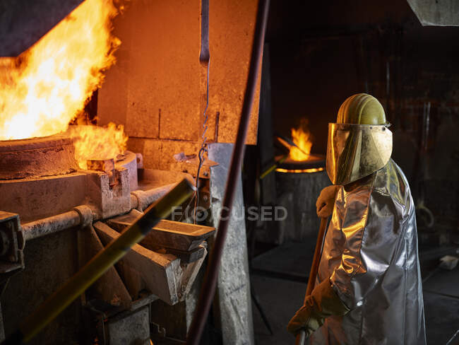Industry, worker at furnace during melting copper, wearing a fire proximity suit — Stock Photo
