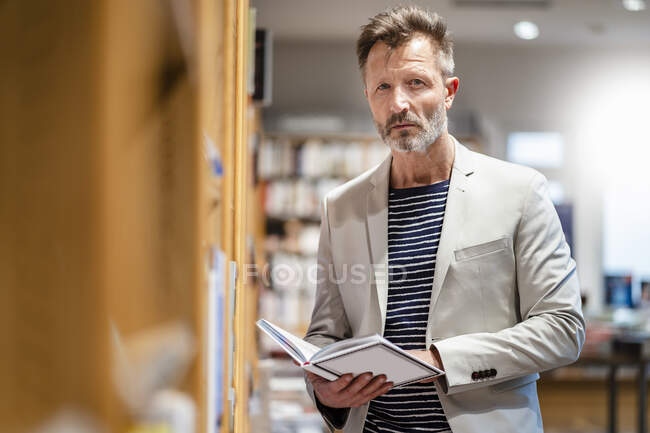 Портрет зрелого мужчины в книжном магазине — стоковое фото