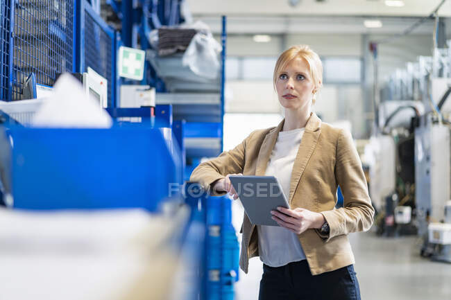 Geschäftsfrau mit Tablet in Fabrikhalle — Stockfoto