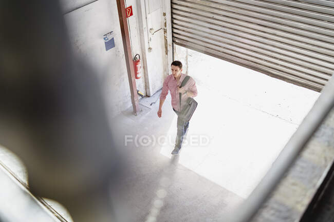 Vista de pájaro del empleado caminando en el muelle de carga en una fábrica - foto de stock