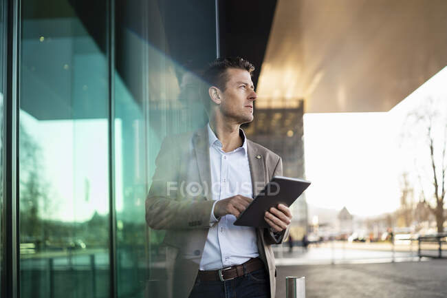 Geschäftsmann mit Tablet vor einem Gebäude in der Stadt — Stockfoto