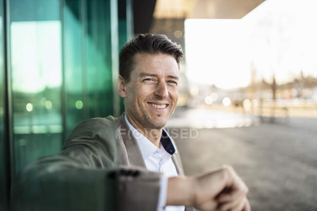 Porträt eines lächelnden Geschäftsmannes vor einem Gebäude in der Stadt — Stockfoto