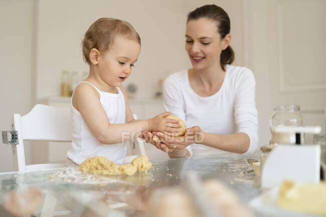 Mãe e filha fazendo um bolo juntos na cozinha em casa — Fotografia de Stock