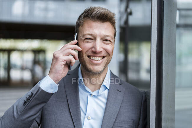 Portrait d'homme d'affaires heureux sur téléphone portable en plein air — Photo de stock