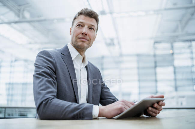 Geschäftsmann mit Tablet am Tisch — Stockfoto