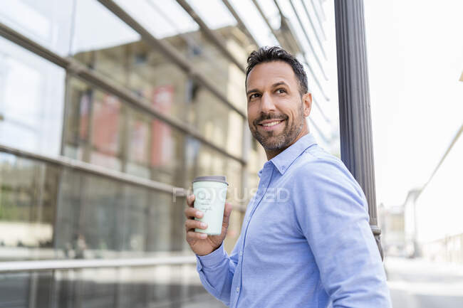 Портрет усміхненого бізнесмена з кавою в місті. — стокове фото