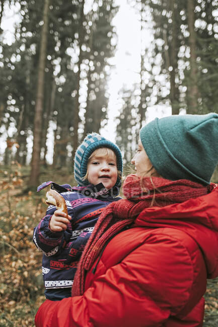 Mãe carregando pequena filha na floresta outonal — Fotografia de Stock