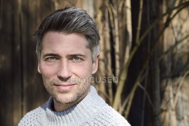 Portrait of mature man with greying hair and grey pullover — Stock Photo