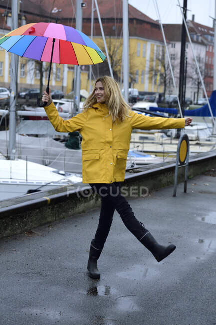 Denmark, Copenhagen, happy woman with colourful umbrella at city harbour — Stock Photo