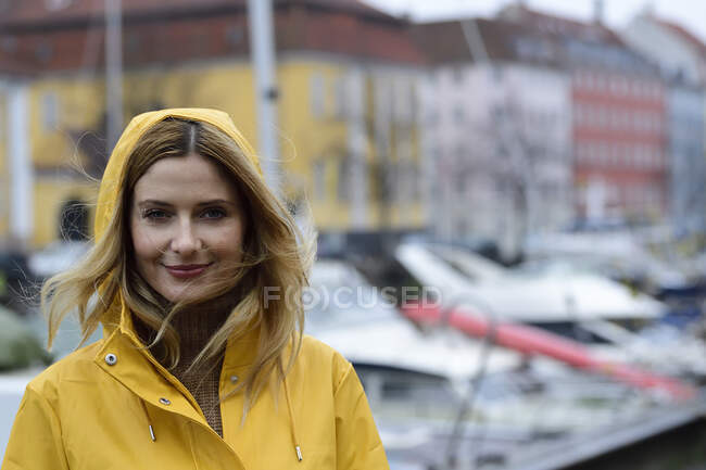 Danimarca, Copenaghen, ritratto di una donna sorridente al porto della città in caso di pioggia — Foto stock