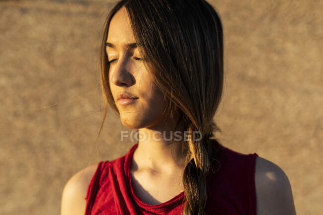 Portrait of teenage girl with closed eyes in sunlight — Stock Photo