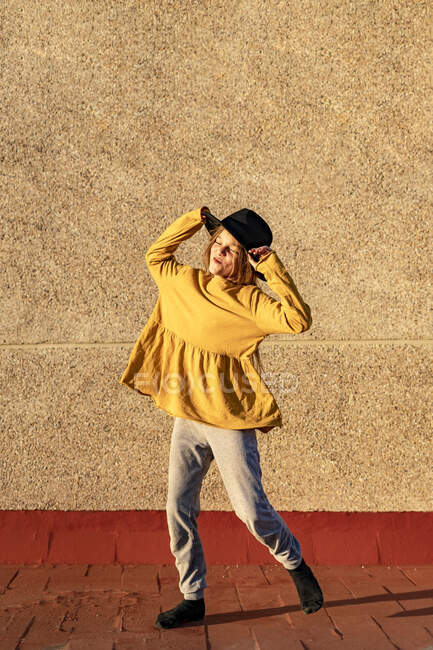 Happy girl wearing oversized hat dancing on root terrace — Stock Photo