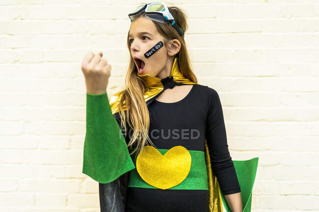 Ragazza in costume da super eroina con cerotto sulla guancia — Foto stock