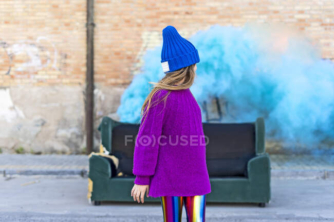 Молода дівчина з диваном і бірюзовим кольором порошку на задньому плані — стокове фото