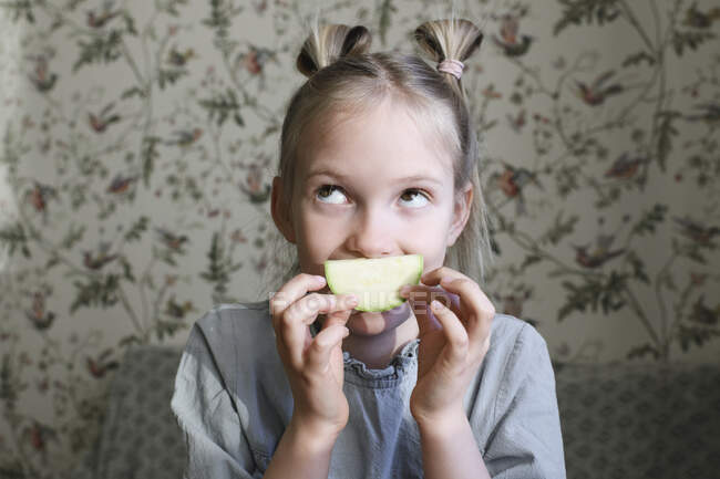Portrait of blond girl with slice of courgette — Stock Photo