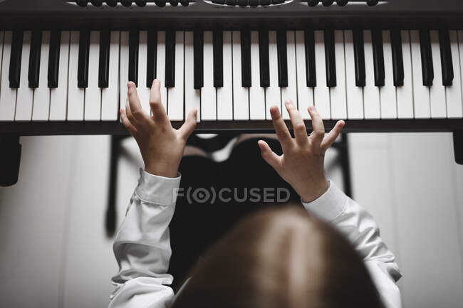 Vista superior de una chica jugando sintetizador - foto de stock