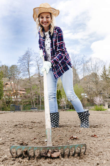 Young woman raking and gardening — Stock Photo