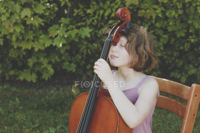 Uma menina fazendo uma pausa durante seus exercícios de violoncelo — Fotografia de Stock
