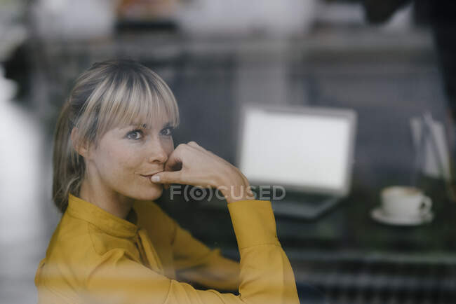 Femme d'affaires blonde assise à la fenêtre, pensant — Photo de stock