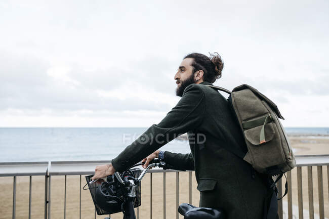 Mann mit E-Bike macht Pause an Strandpromenade — Stockfoto