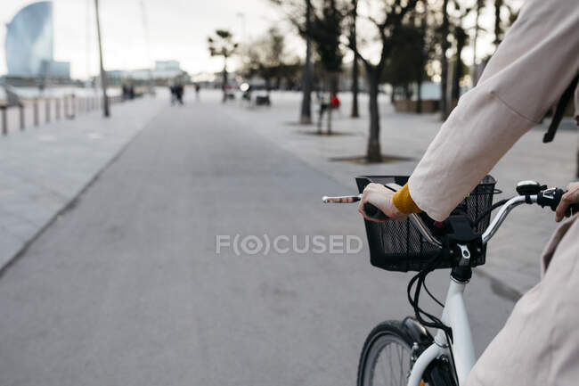 Nahaufnahme einer Frau, die auf einer Promenade mit dem E-Bike unterwegs ist — Stockfoto