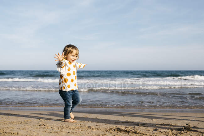 Menina feliz correndo descalça na praia — Fotografia de Stock