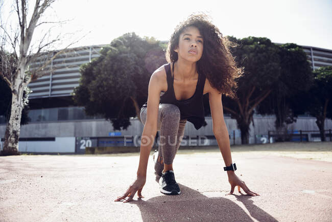 Sportliche junge Frau startet auf Tartanbahn — Stockfoto