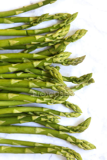 Row of green asparagus on white background — Stock Photo