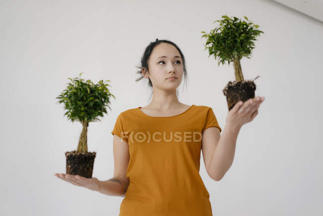 Giovane donna con due alberi di bonsai — Foto stock