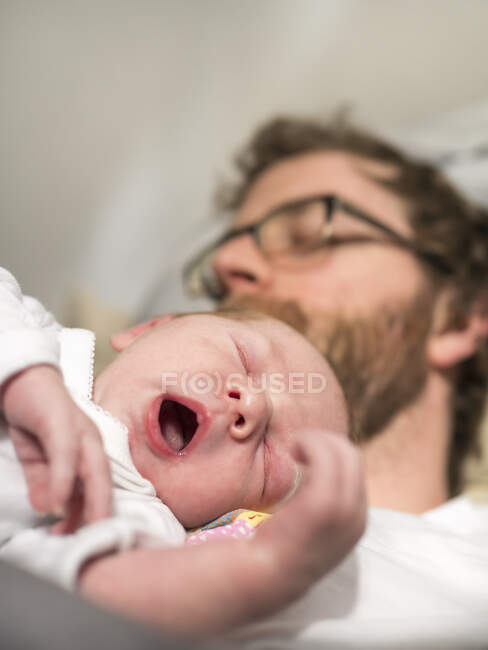 Батько і новонароджена дівчинка сплять. — стокове фото