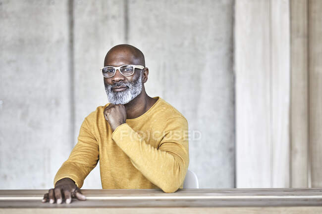 Портрет уверенного зрелого бизнесмена, сидящего за столом в офисе — стоковое фото