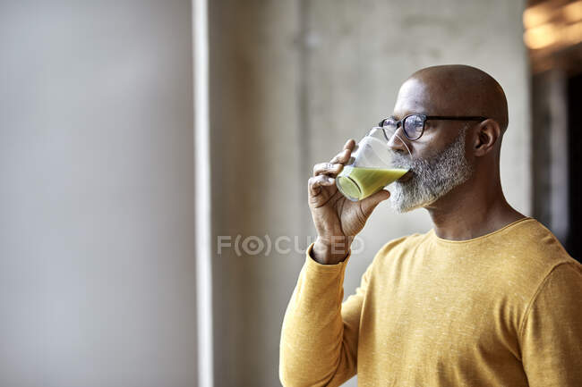 Mature businessman in office drinking a smoothie — authenticity, workplace  - Stock Photo | #458869728