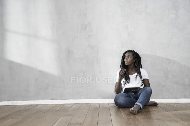 Ritratto di donna seduta sul pavimento con tavoletta digitale — Foto stock