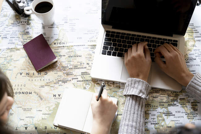 Friends using laptop, planning vacation — Stock Photo